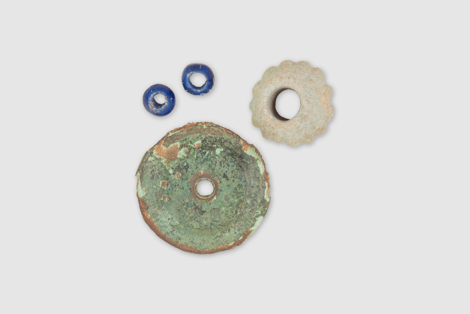 Collana o bracciale con due perline in vetro blu, una perla in <em>faience</em> azzurra e una lamina circolare in bronzo